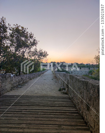 Experience the Serene Sunset Over a Historic Pathway, where peace meets beauty at dusk 133021937