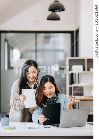 Two Attractive young Asian female college students working on the school project using laptop 133021964