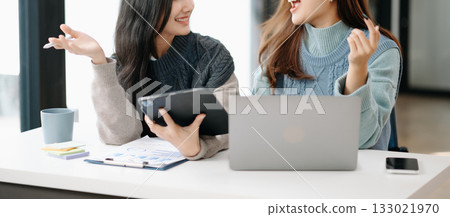 Two business workers talking on the smartphone and using laptop at modern office. Two business workers talking on the smartphone and using laptop at modern office. 133021970