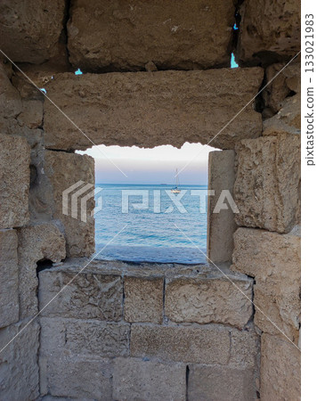 A Scenic View Through a Historic Stone Wall Located by the Beautiful Sea and Coastline A Scenic View Through a Historic Stone Wall Located by the Beautiful Sea and Coastline 133021983