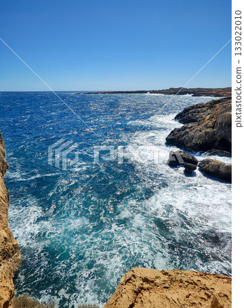 Experience the stunning and breathtaking coastal view with rolling waves and a clear blue sky Experience the stunning and breathtaking coastal view with rolling waves and a clear blue sky 133022010