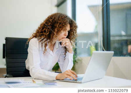 Successful businesswoman in office working on laptop.for doing math finance on an office desk, tax, report Successful businesswoman in office working on laptop.for doing math finance on an office desk, tax, report 133022079