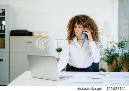 Successful businesswoman in office working on laptop.for doing math finance on an office desk, tax, report Successful businesswoman in office working on laptop.for doing math finance on an office desk, tax, report 133022131