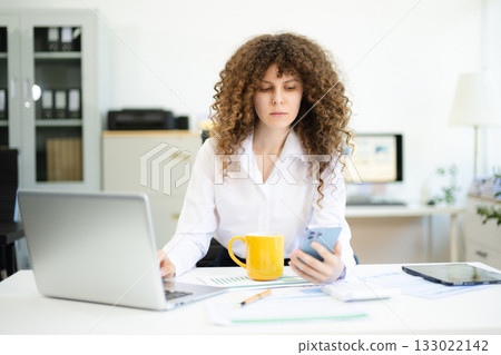 Successful businesswoman in office working on laptop.for doing math finance on an office desk, tax, report 133022142