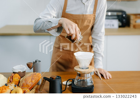Closeup of barista brewing pour over coffee at home. Warm lifestyle concept featuring hand-crafted drip process, Closeup of barista brewing pour over coffee at home. Warm lifestyle concept featuring hand-crafted drip process, 133022243