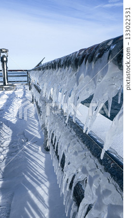 Beautiful Icicles Forming on a Metal Fence with Sunlight Creating a Sparkling Effect in Winter Beautiful Icicles Forming on a Metal Fence with Sunlight Creating a Sparkling Effect in Winter 133022531