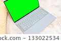 Green mockup of a sleek laptop with blank screen on a soft fur surface, ideal for showcasing designs and creative projects with copy space 133022534