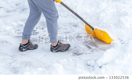 Man shoveling snow off of his driveway after a winter storm in Canada. Man with snow shovel cleans sidewalks in winter. Winter time. Man shoveling snow off of his driveway after a winter storm in Canada. Man with snow shovel cleans sidewalks in winter. Winter time. 133022536