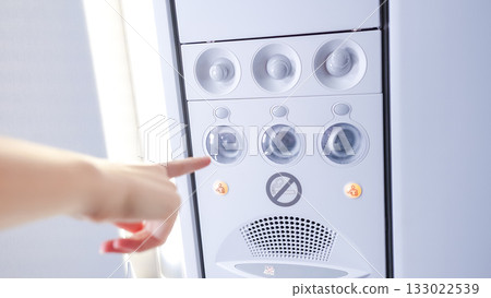 Hand pressing button on modern air conditioning unit, showcasing user interaction with technology and comfort in indoor environment 133022539