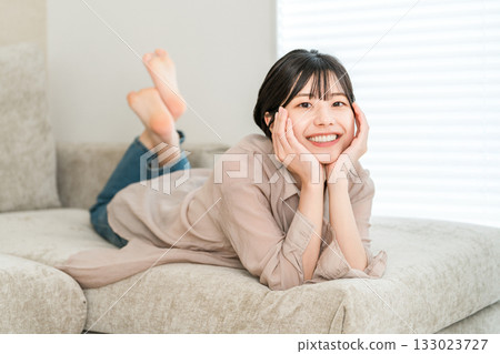 Young Asian woman relaxing on the sofa 133023727