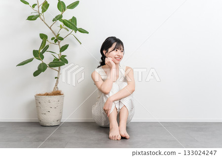 坐在地板上微笑的美麗亞洲女人（美容、飲食、脫毛） 133024247