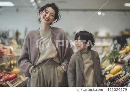 笑容滿面的母子購物場景 | 父母和兒子並肩走在超市過道裡 133024379