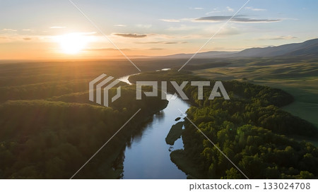 Aerial view of a winding river at sunset with lush green forest 133024708