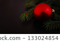Christmas red ornament and spruce branch on a black background. 133024854
