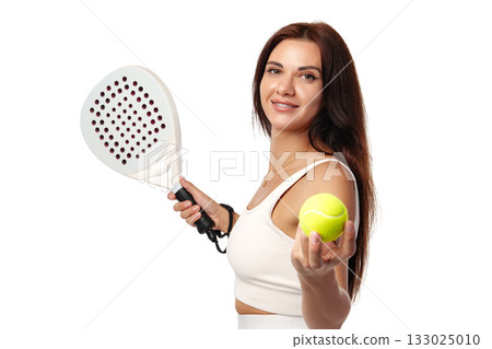 Smiling woman holding a paddle and a tennis ball in a bright setting 133025010
