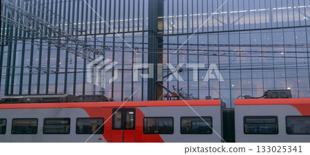 Train in motion in front of a modern building. 133025341