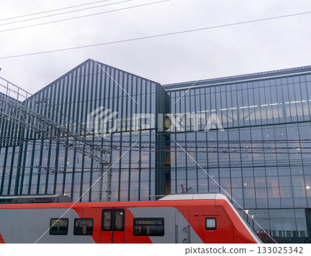 Modern high-speed train on the background of the modern office building Modern high-speed train on the background of the modern office building 133025342