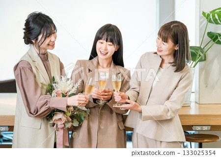 Businesswomen lining up in the office with champagne (farewell party, teamwork, rally, victory party, celebration) 133025354
