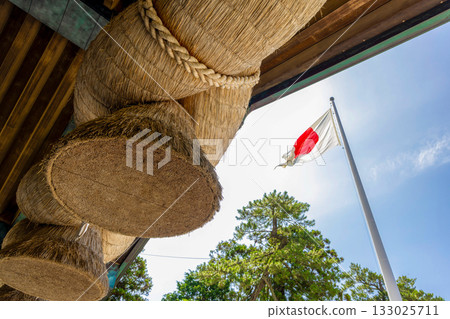 (Shimane Prefecture) Izumo Taisha Shrine: The large shimenawa rope and national flag at the Kagura Hall (Shimane Prefecture) Izumo Taisha Shrine: The large shimenawa rope and national flag at the Kagura Hall 133025711