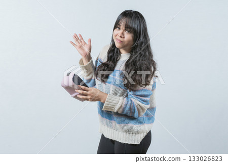 Worried girl with no money holding empty wallet, isolated. Young woman shaking her empty wallet Worried girl with no money holding empty wallet, isolated. Young woman shaking her empty wallet 133026823