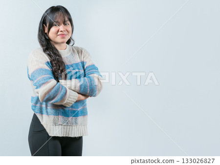 Attractive young Asian woman with arms crossed isolated. Portrait of beautiful and smiling Asian woman on white background 133026827