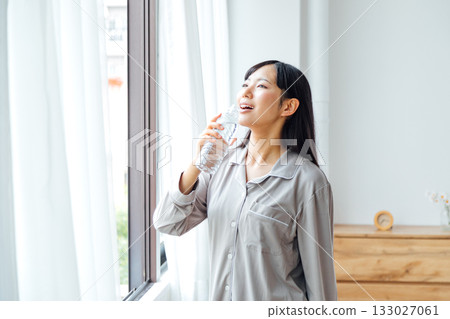 A young woman's well-being-conscious lifestyle: Morning routine of drinking water 133027061