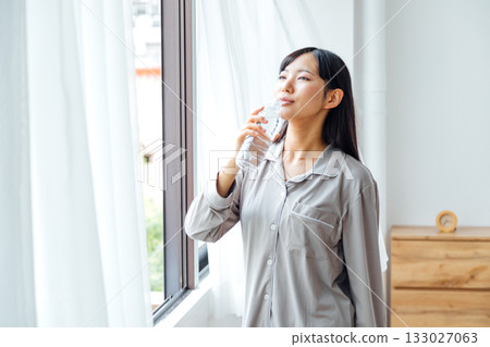 A young woman's well-being-conscious lifestyle: Morning routine of drinking water A young woman's well-being-conscious lifestyle: Morning routine of drinking water 133027063