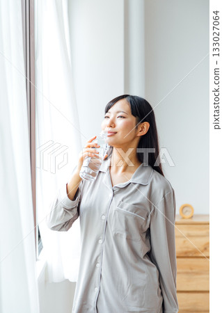 A young woman's well-being-conscious lifestyle: Morning routine of drinking water A young woman's well-being-conscious lifestyle: Morning routine of drinking water 133027064