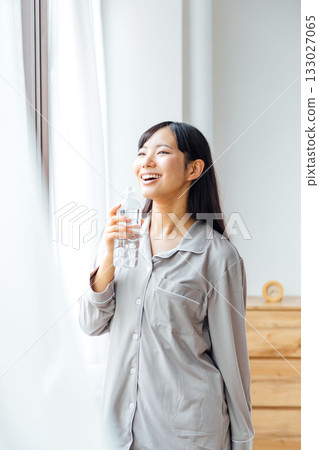 A young woman's well-being-conscious lifestyle: Morning routine of drinking water A young woman's well-being-conscious lifestyle: Morning routine of drinking water 133027065
