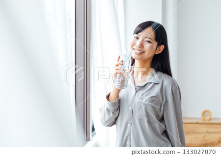 A young woman's well-being-conscious lifestyle: Morning routine of drinking water 133027070