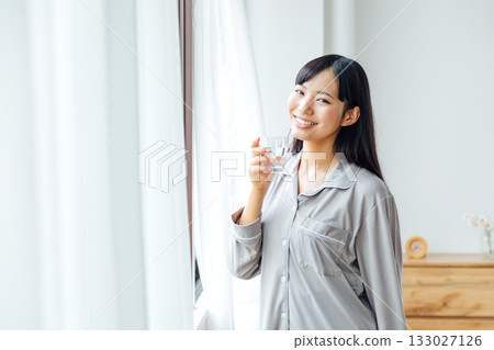 A young woman's well-being-conscious lifestyle: Morning routine of drinking water 133027126