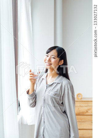 A young woman's well-being-conscious lifestyle: Morning routine of drinking water 133027132