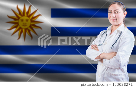 Female doctor on Uruguay flag. Doctor with crossed arms on Uruguay flag. Uruguay health and care concept Female doctor on Uruguay flag. Doctor with crossed arms on Uruguay flag. Uruguay health and care concept 133028271