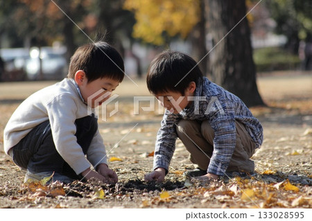 兩個男孩在秋日的公園玩泥巴,玩得不亦樂乎。 兩個男孩在秋日的公園玩泥巴,玩得不亦樂乎。 133028595