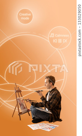 Creative artwork. Focused man painting in calm creative mode with futuristic interface on orange background. Creative artwork. Focused man painting in calm creative mode with futuristic interface on orange background. 133029050