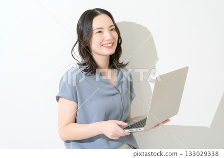 Japanese woman holding a laptop on a white background Japanese woman holding a laptop on a white background 133029338