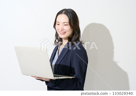 Japanese woman holding a laptop on a white background 133029340