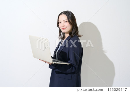 Japanese woman holding a laptop on a white background 133029347