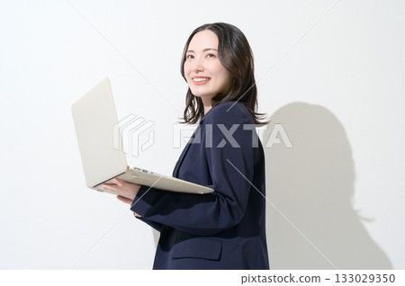 一位日本女性在白色背景下拿著筆記型電腦。 133029350