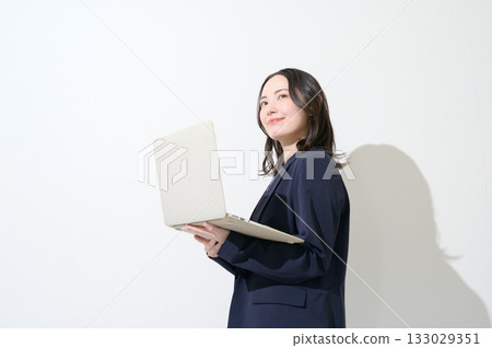 Japanese woman holding a laptop on a white background 133029351