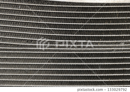metal radiator parts of a car damaged after an accident on the road, part of the radiator of the car cooling system 133029792