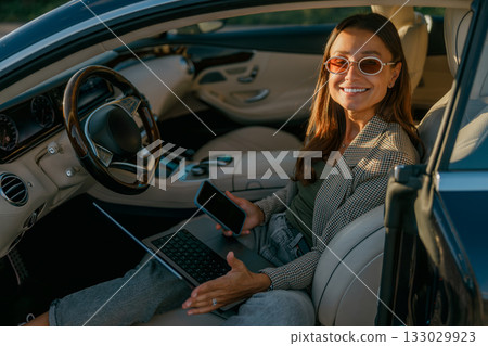 Executive woman balancing communication devices during important deal Executive woman balancing communication devices during important deal 133029923