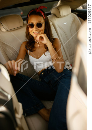 Friendly portrait of woman enjoying sunlight with denim and accessories 133029927