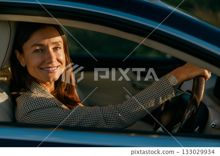 Woman carefully controlling car prior to crucial business gathering 133029934