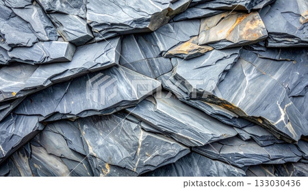The surface contrasts with the rough pattern of the old black stone wall.The surface contrasts with the rough pattern of the old black stone wall. 133030436