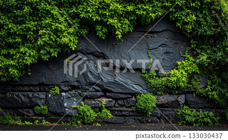 The surface contrasts with the rough pattern of the old black stone wall.The surface contrasts with the rough pattern of the old black stone wall. 133030437