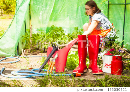 Female farmer and gardening tools in garden Female farmer and gardening tools in garden 133030521