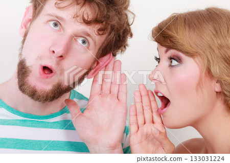 Woman telling an astonished man some secrets 133031224
