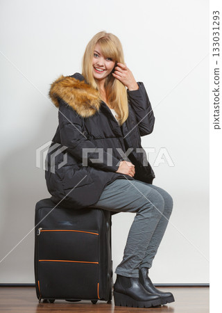 Happy young woman in warm jacket with suitcase. Happy young woman in warm jacket with suitcase. 133031293