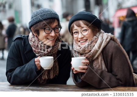 在冬日咖啡館露台上，一對戀人相視而笑——寧靜的片刻。 133031535